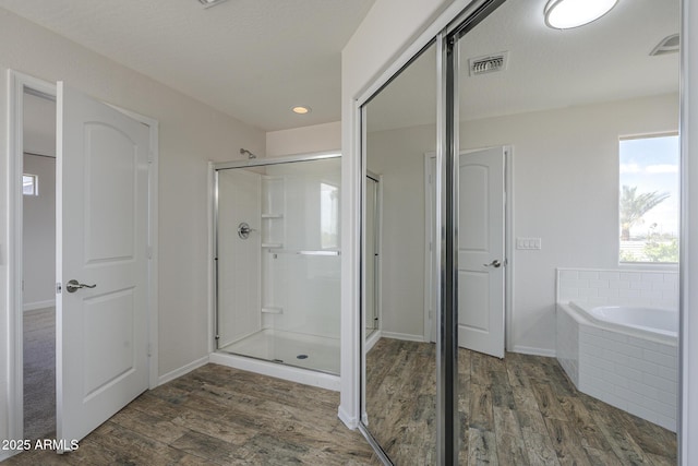8518 S 8th Ln, Phoenix, AZ 85041 - full bath with wood finished floors, a shower stall, a bath, baseboards, and recessed lighting