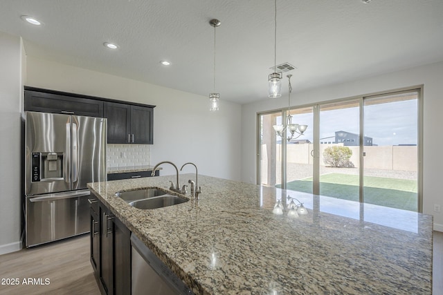 8518 S 8th Ln, Phoenix, AZ 85041 - kitchen featuring appliances with stainless steel finishes, a sink, light wood-style flooring, light stone counters, and recessed lighting
