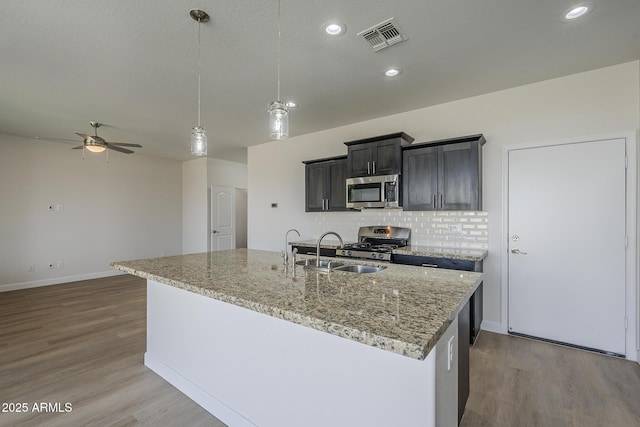 8518 S 8th Ln, Phoenix, AZ 85041 - kitchen featuring stainless steel appliances, ceiling fan, wood finished floors, tasteful backsplash, and a sink