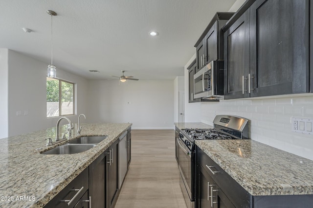 8518 S 8th Ln, Phoenix, AZ 85041 - kitchen featuring appliances with stainless steel finishes, a sink, light wood-style floors, tasteful backsplash, and a ceiling fan
