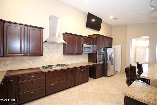 5437 W Bluefield Ave, Glendale, AZ 85308 - kitchen featuring wall chimney range hood, appliances with stainless steel finishes, arched walkways, and decorative backsplash