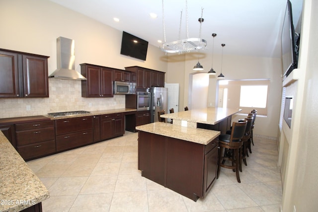 5437 W Bluefield Ave, Glendale, AZ 85308 - kitchen with wall chimney exhaust hood, appliances with stainless steel finishes, backsplash, light tile patterned floors, and a kitchen bar