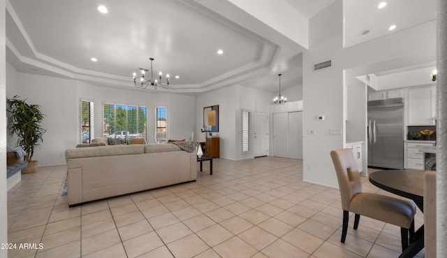 tiled living room featuring a raised ceiling and a chandelier