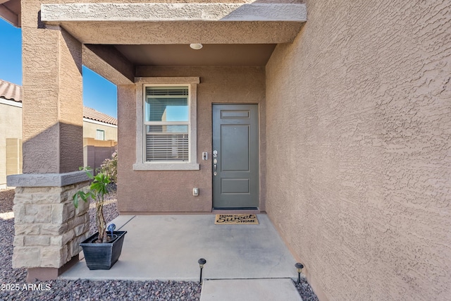 view of exterior entry featuring stucco siding