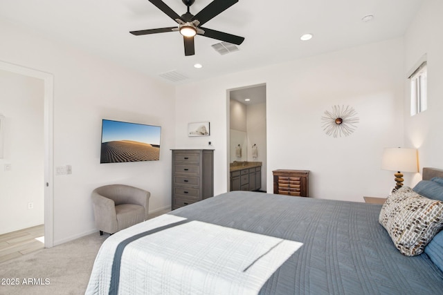 carpeted bedroom featuring ensuite bath and ceiling fan