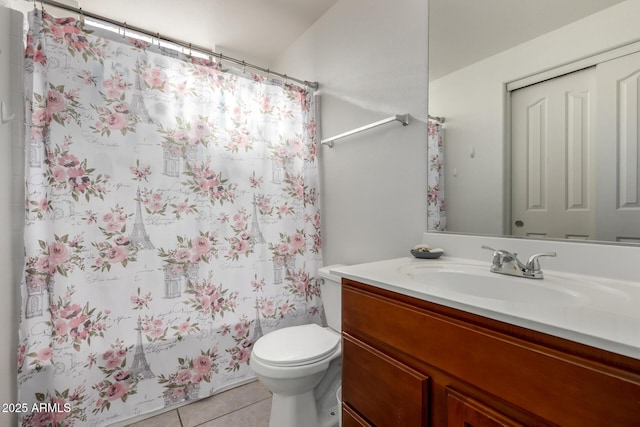 bathroom with toilet, vanity, and tile patterned flooring