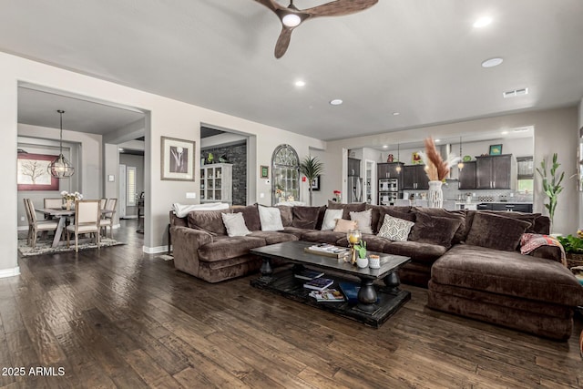 living room with visible vents, ceiling fan with notable chandelier, dark wood-style floors, recessed lighting, and baseboards