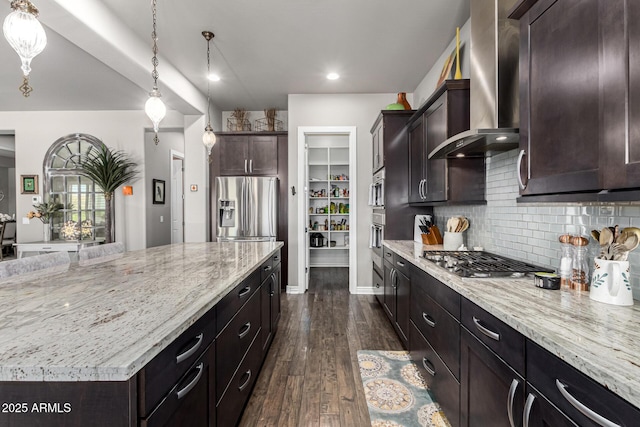 kitchen featuring light stone counters, wall chimney exhaust hood, dark wood-style floors, and stainless steel appliances