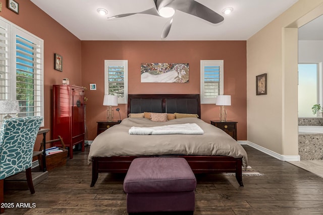 bedroom with connected bathroom, baseboards, dark wood-type flooring, and a ceiling fan