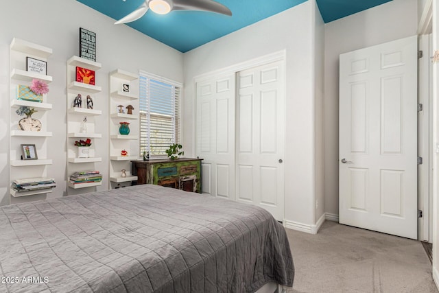 bedroom featuring a closet, light colored carpet, baseboards, and ceiling fan