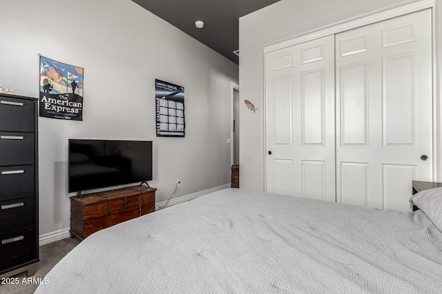 bedroom featuring baseboards, a closet, and dark colored carpet