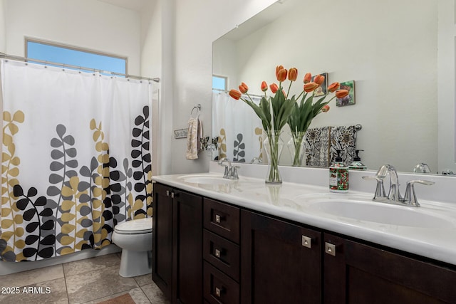 bathroom with curtained shower, double vanity, toilet, and a sink