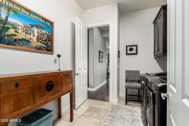 hallway with washer and dryer, baseboards, and light tile patterned flooring