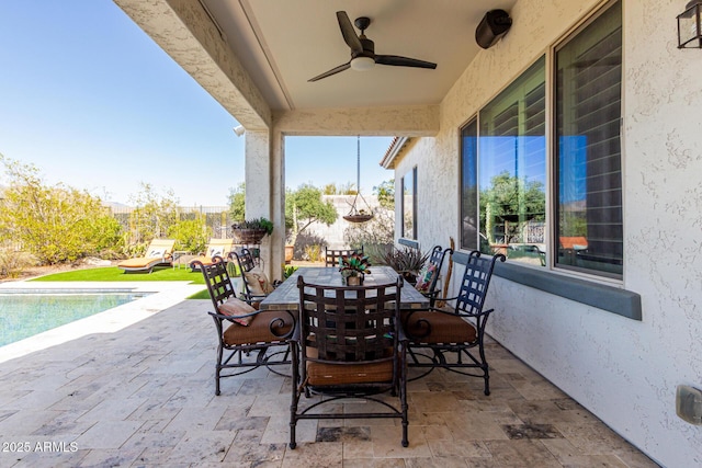 view of patio / terrace with an outdoor pool, outdoor dining area, and a ceiling fan