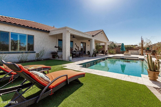 pool with a lawn, a fenced backyard, a ceiling fan, and a patio area