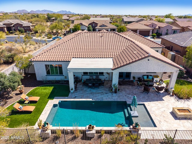 back of house featuring a patio area, a tiled roof, and a fenced backyard