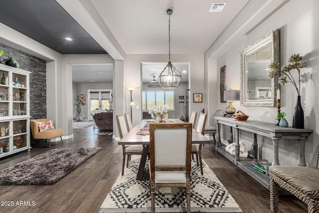 dining space featuring visible vents, baseboards, an inviting chandelier, and dark wood-style floors