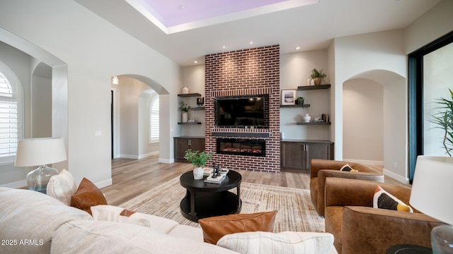 living room with a healthy amount of sunlight, a fireplace, and light hardwood / wood-style flooring