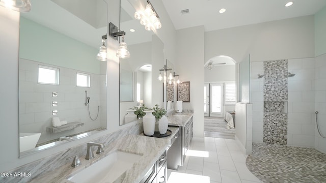 bathroom featuring tile patterned flooring, vanity, and tiled shower