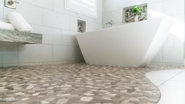 bathroom with a bath and tile walls