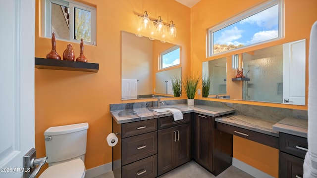 bathroom featuring vanity, walk in shower, and toilet