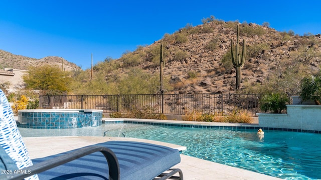 view of pool featuring an in ground hot tub, pool water feature, and a mountain view