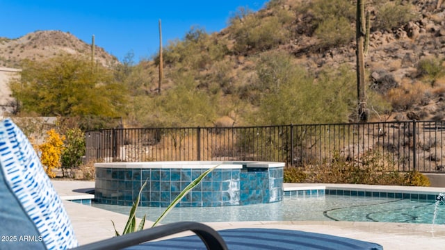 view of pool with a mountain view and pool water feature