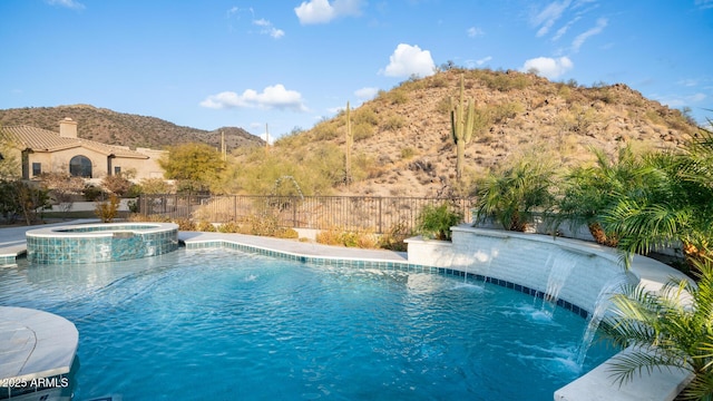 view of swimming pool featuring an in ground hot tub, pool water feature, and a mountain view