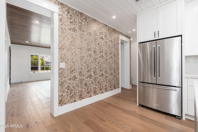 kitchen featuring light hardwood / wood-style flooring, high end refrigerator, wooden ceiling, and white cabinets