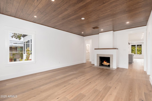 unfurnished living room featuring a fireplace, light hardwood / wood-style flooring, and wooden ceiling