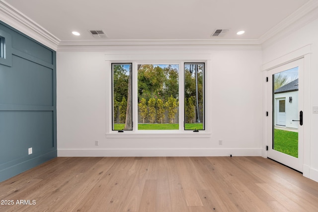 empty room with ornamental molding, light hardwood / wood-style floors, and plenty of natural light