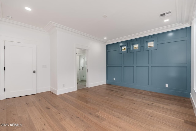 spare room with crown molding and light hardwood / wood-style flooring