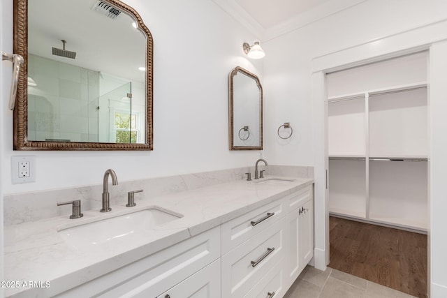 bathroom featuring an enclosed shower, vanity, and crown molding