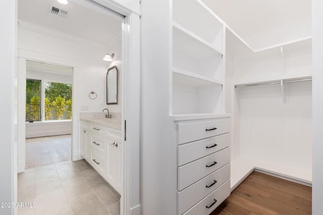 walk in closet featuring sink and light hardwood / wood-style flooring