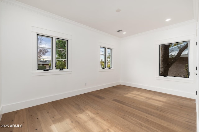 empty room with crown molding and light hardwood / wood-style flooring