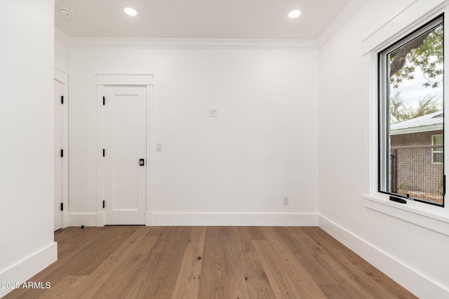 spare room with ornamental molding and light hardwood / wood-style floors