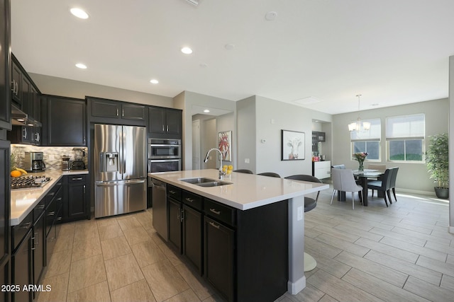 20702 W Hillcrest Blvd, Buckeye, AZ 85396 - kitchen featuring stainless steel appliances, a chandelier, light countertops, backsplash, and recessed lighting