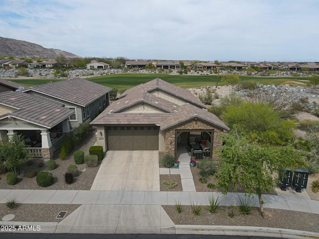 20702 W Hillcrest Blvd, Buckeye, AZ 85396 - view of front facade with an attached garage, a residential view, driveway, stone siding, and a mountain view