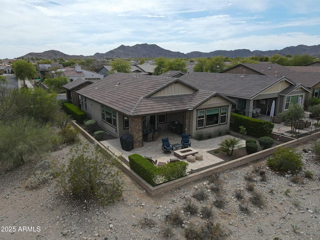 20702 W Hillcrest Blvd, Buckeye, AZ 85396 - rear view of property featuring a fire pit, a patio area, a mountain view, and a tile roof