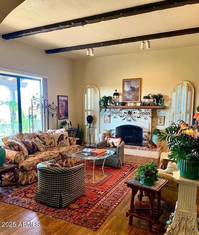 100 N Lazy Fox Rd Unit 8, Wickenburg, AZ 85390 - living area featuring beamed ceiling, wood finished floors, and a fireplace
