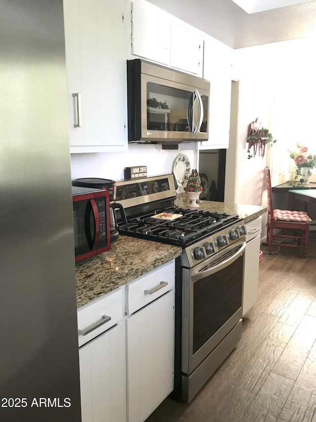 100 N Lazy Fox Rd Unit 8, Wickenburg, AZ 85390 - kitchen featuring stainless steel appliances, dark wood-type flooring, white cabinets, and stone counters