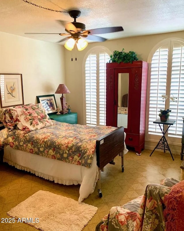 100 N Lazy Fox Rd Unit 8, Wickenburg, AZ 85390 - bedroom featuring light flooring, a textured ceiling, and ceiling fan