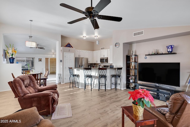 living room with lofted ceiling, light hardwood / wood-style floors, and ceiling fan