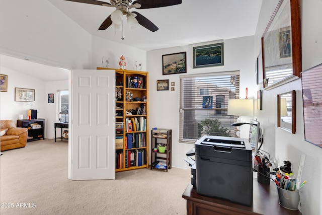 carpeted office with lofted ceiling, plenty of natural light, and ceiling fan