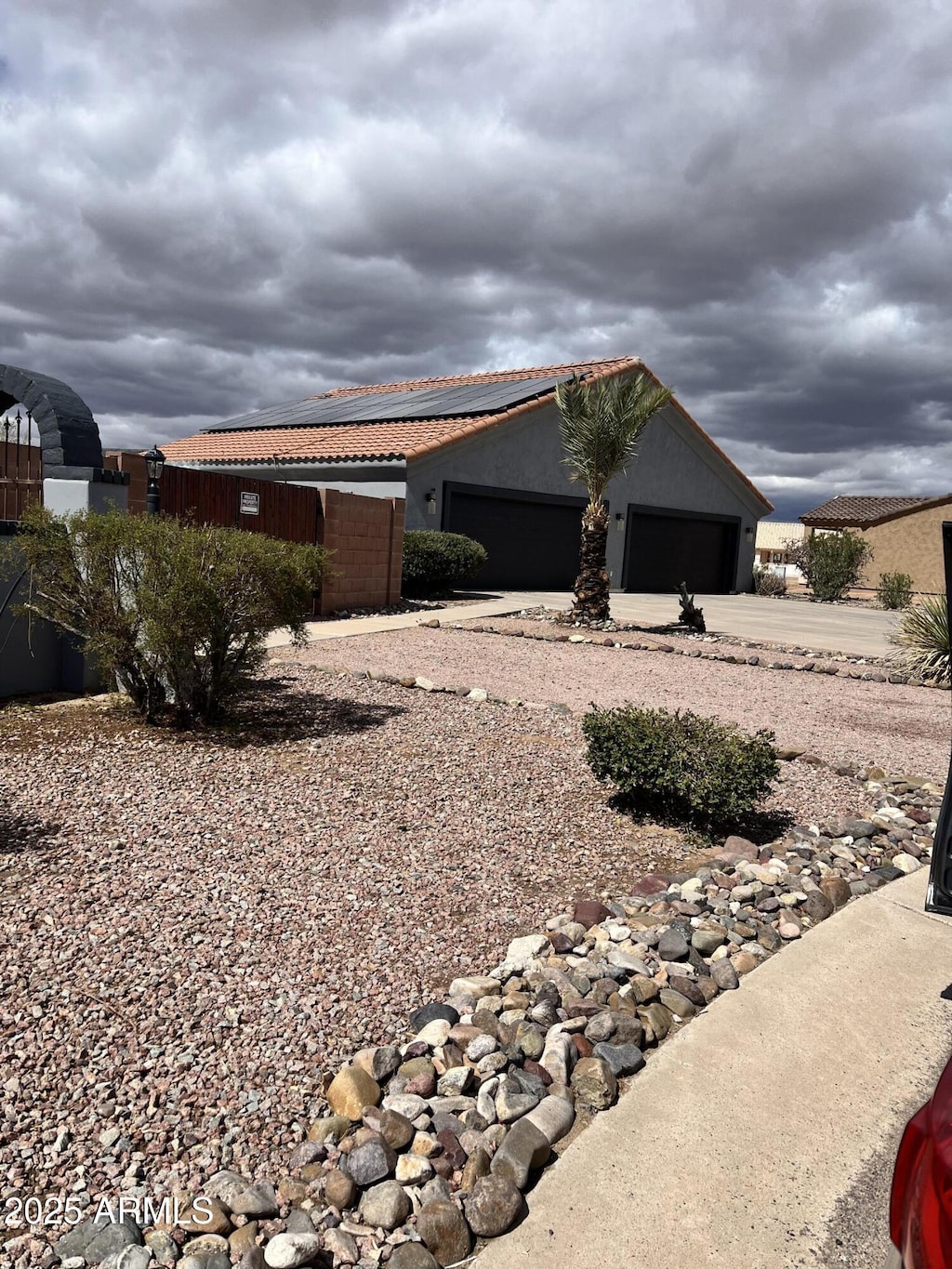 view of home's exterior featuring stucco siding, concrete driveway, an attached garage, and a tile roof