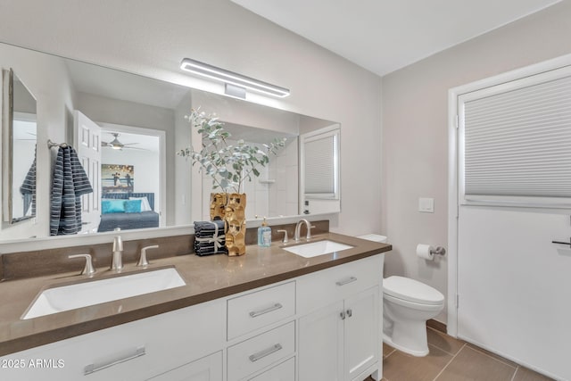 bathroom with tile patterned floors, vanity, toilet, and ceiling fan