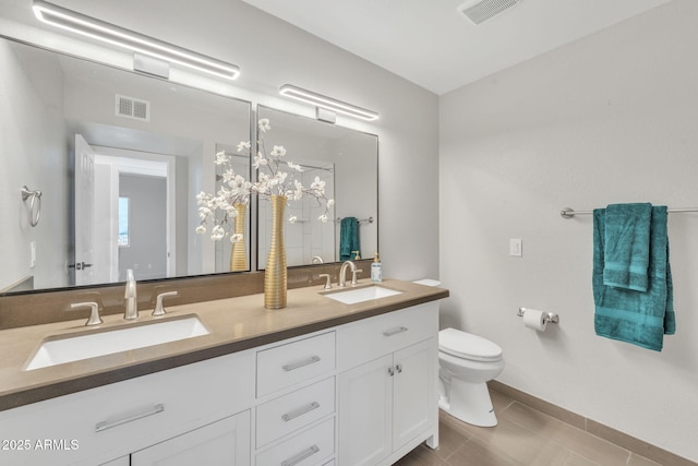 bathroom with tile patterned flooring, vanity, and toilet