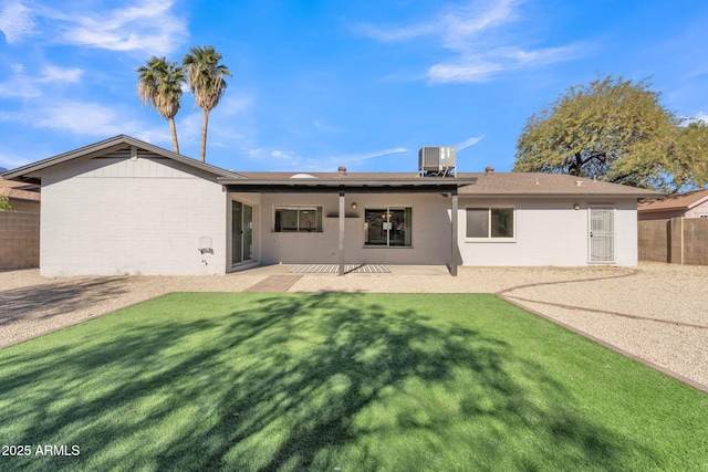 rear view of property with a lawn, a patio area, and central AC