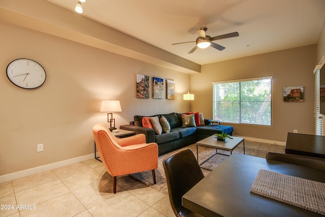 living area with light tile patterned floors, baseboards, and ceiling fan