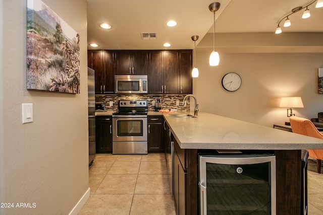 kitchen with wine cooler, visible vents, a sink, backsplash, and stainless steel appliances